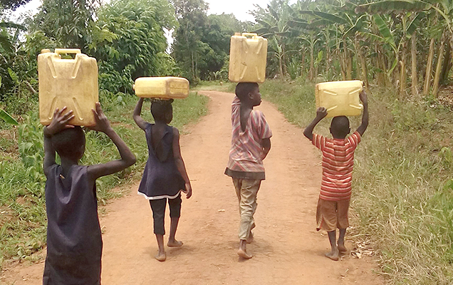 Kinder tragen Wasserkanister
